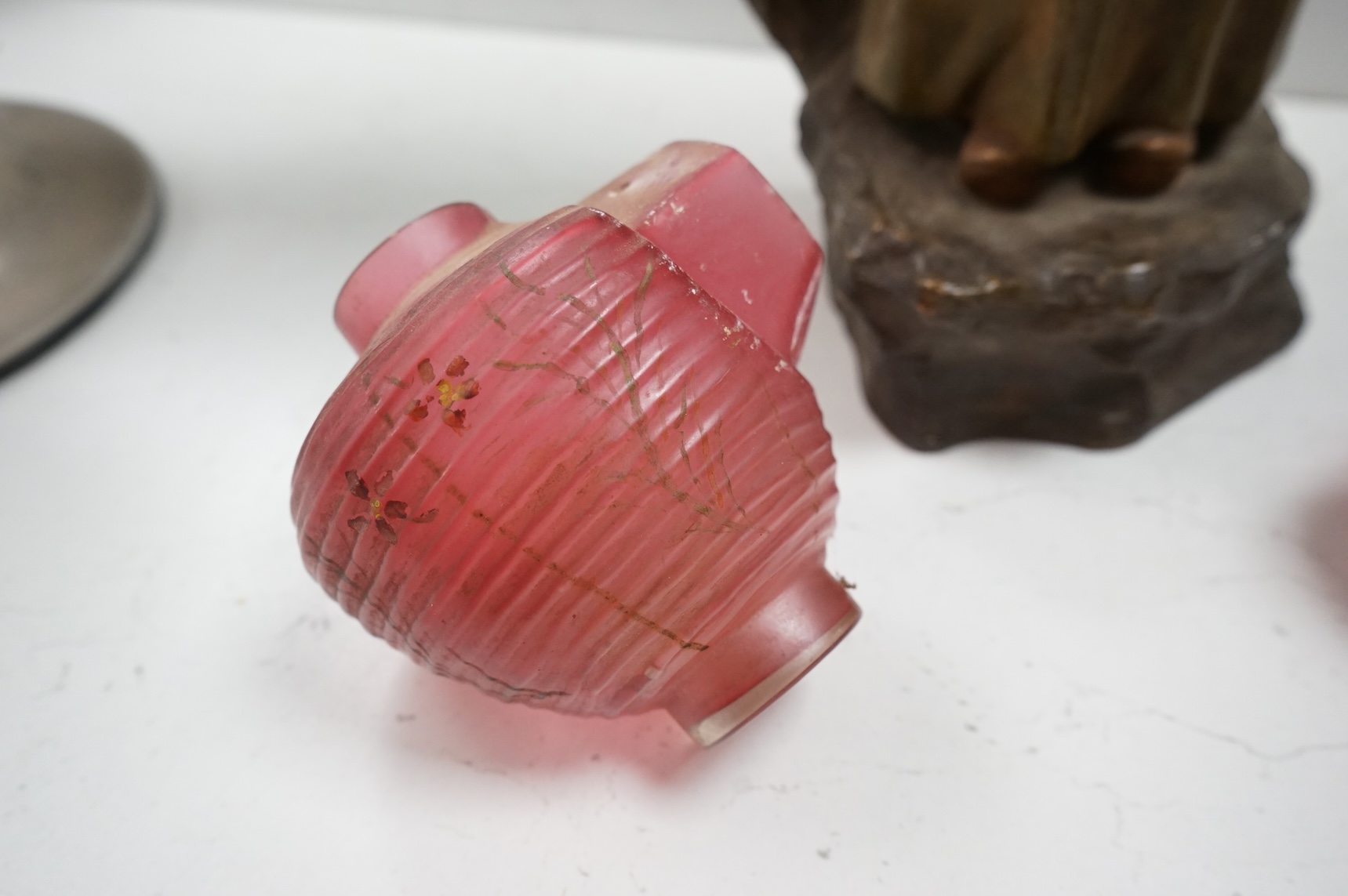 A Goldscheider cold-painted terracotta figural lamp with two cranberry glass shades, 55cm high